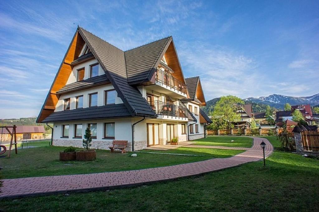 una casa grande con techo de gambrel en Apart-Center Ogrody Górskie, en Zakopane