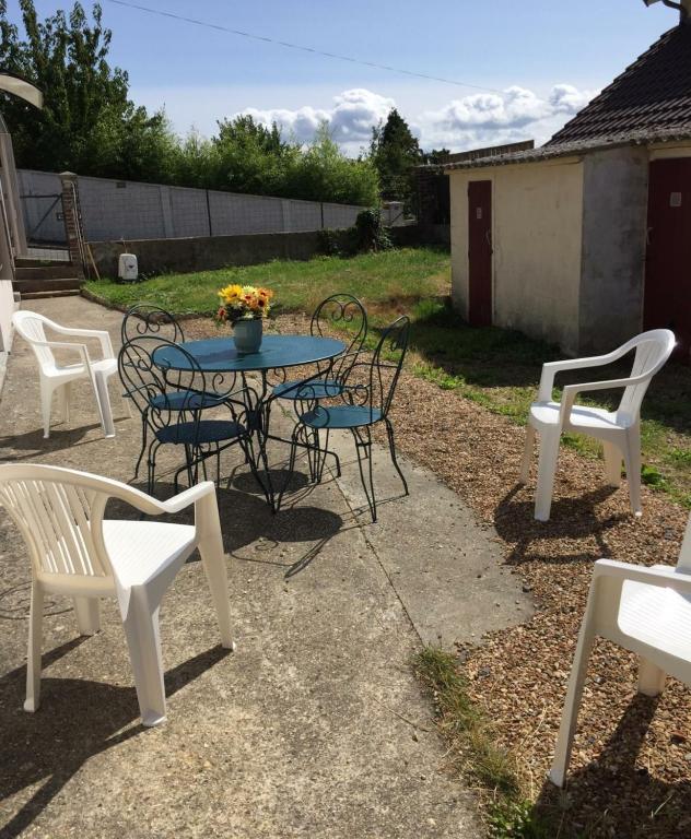 un groupe de chaises, une table et des chaises dans l'établissement Maison de villégiature à Trouville sur Mer, à Trouville-sur-Mer