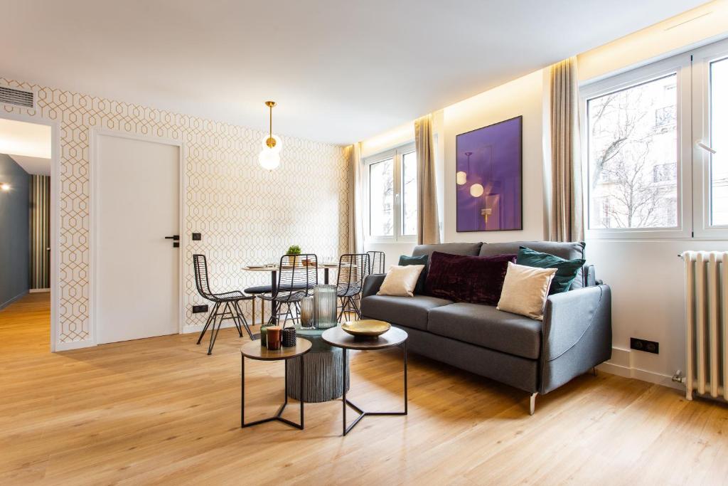 uma sala de estar com um sofá e uma mesa em CMG Résidence Canal Saint-Martin / Vellefaux em Paris
