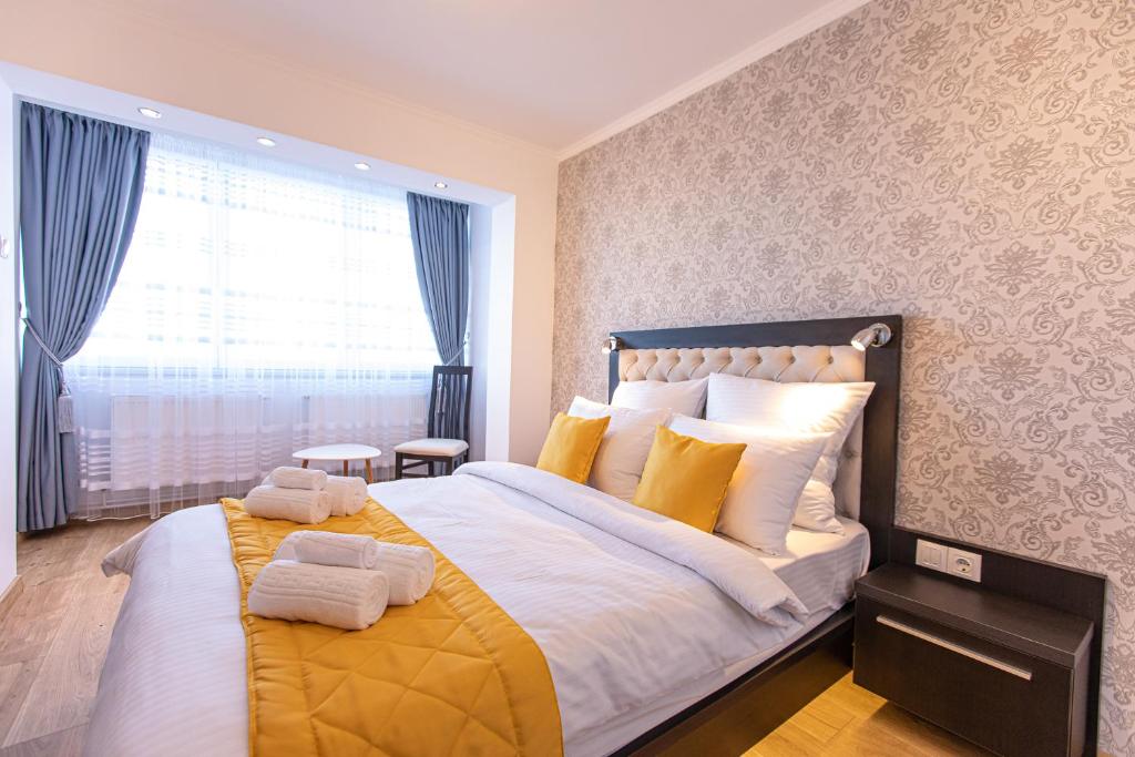 a bedroom with a large bed with towels on it at Laurentiu Apartments in Braşov