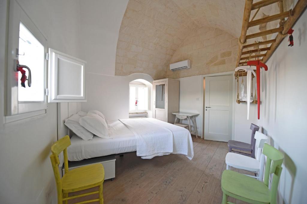 a bedroom with a white bed and two chairs at Casa 3Bien in Matera