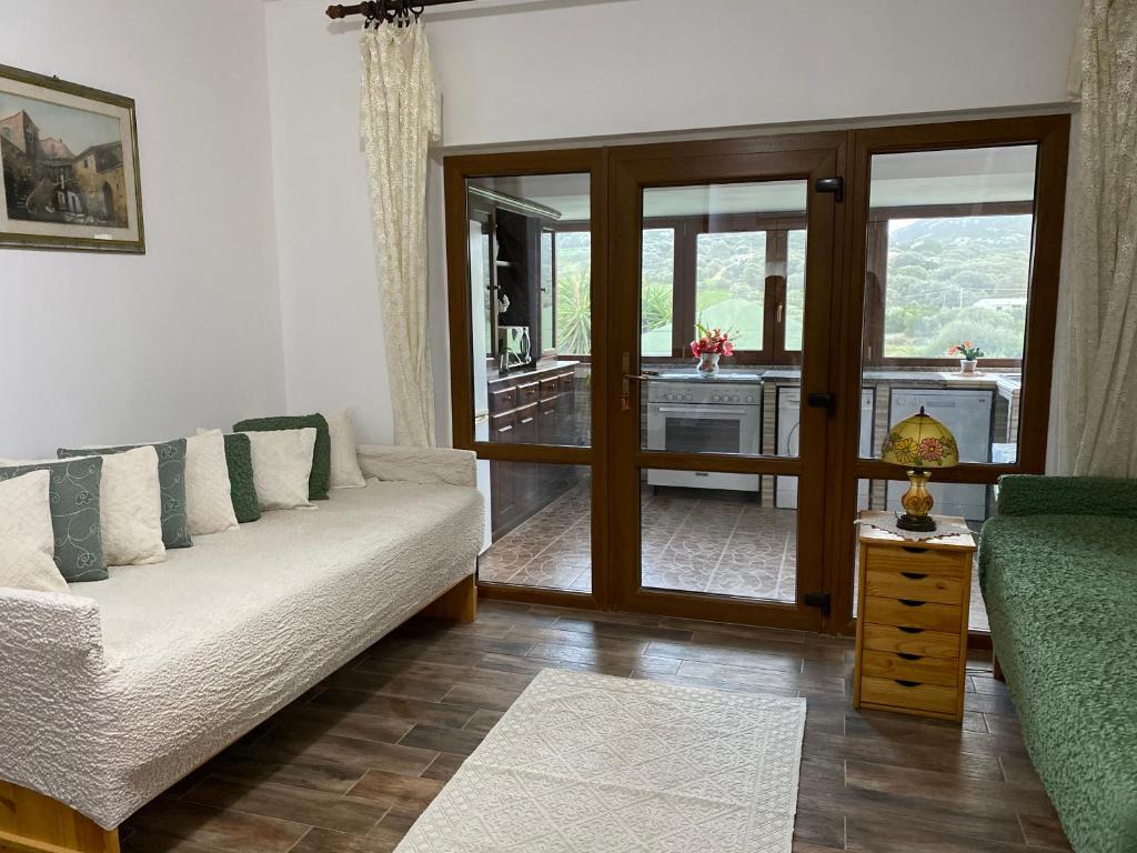 een woonkamer met een bank en een glazen schuifdeur bij Casa Vittoria in Palau