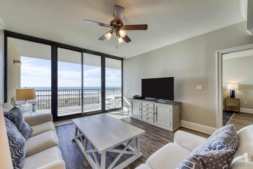 a living room with a couch and a flat screen tv at Holiday Isle in Dauphin Island