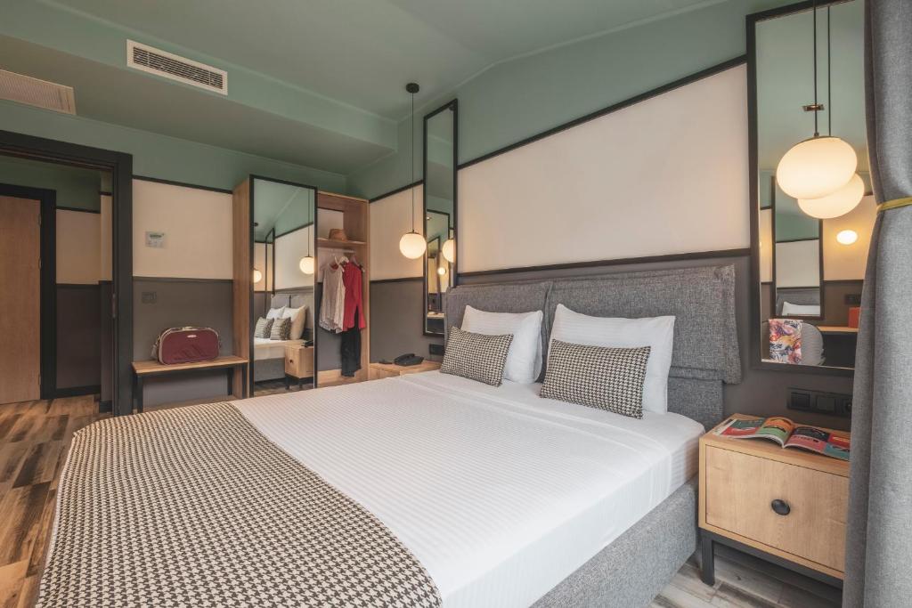 una camera da letto con un grande letto bianco con specchi di City Life Demir Hotel a Fethiye