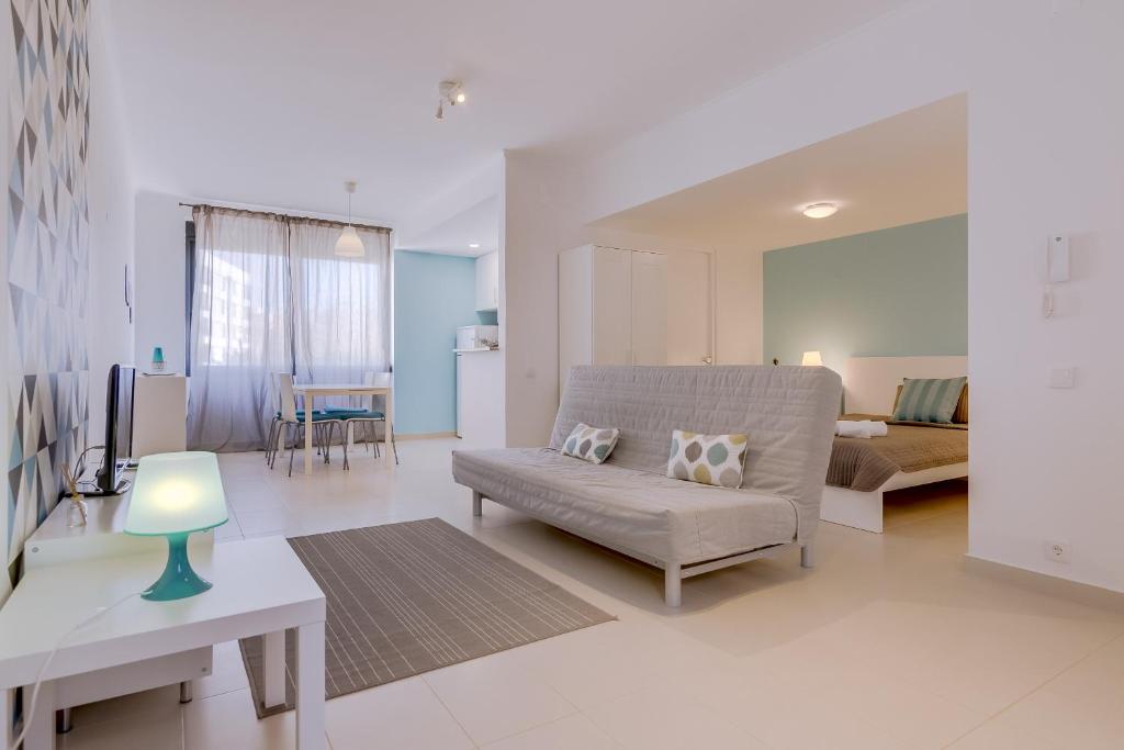 a living room with a couch and a table at Cruzeiro do Sul Apartments - Vilamoura center in Vilamoura