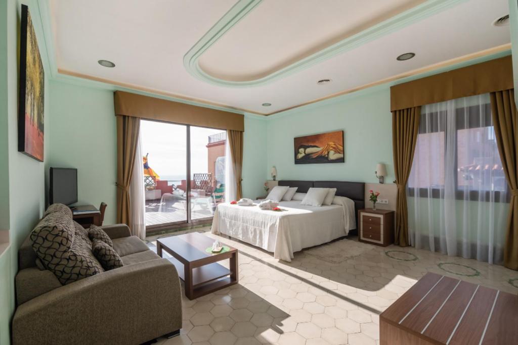 マズノウにあるLlar de Capitansのベッドとソファ付きのホテルルーム