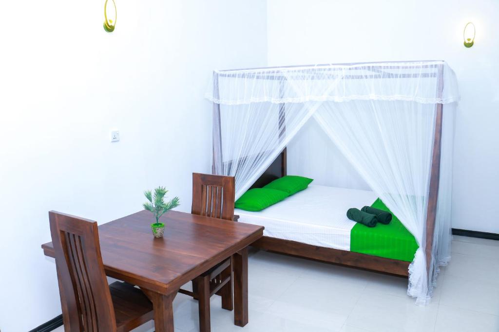 a bedroom with a bed and a table and a table and chair at Beach Breeze Weligama in Weligama