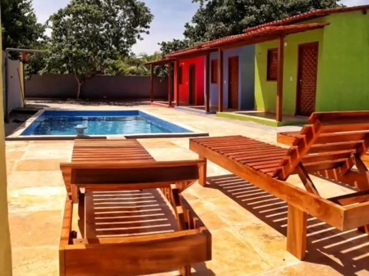 日若卡－迪熱里科阿科阿拉的住宿－Pousada Caminho do Paraíso，一个带两把椅子的庭院和一个游泳池