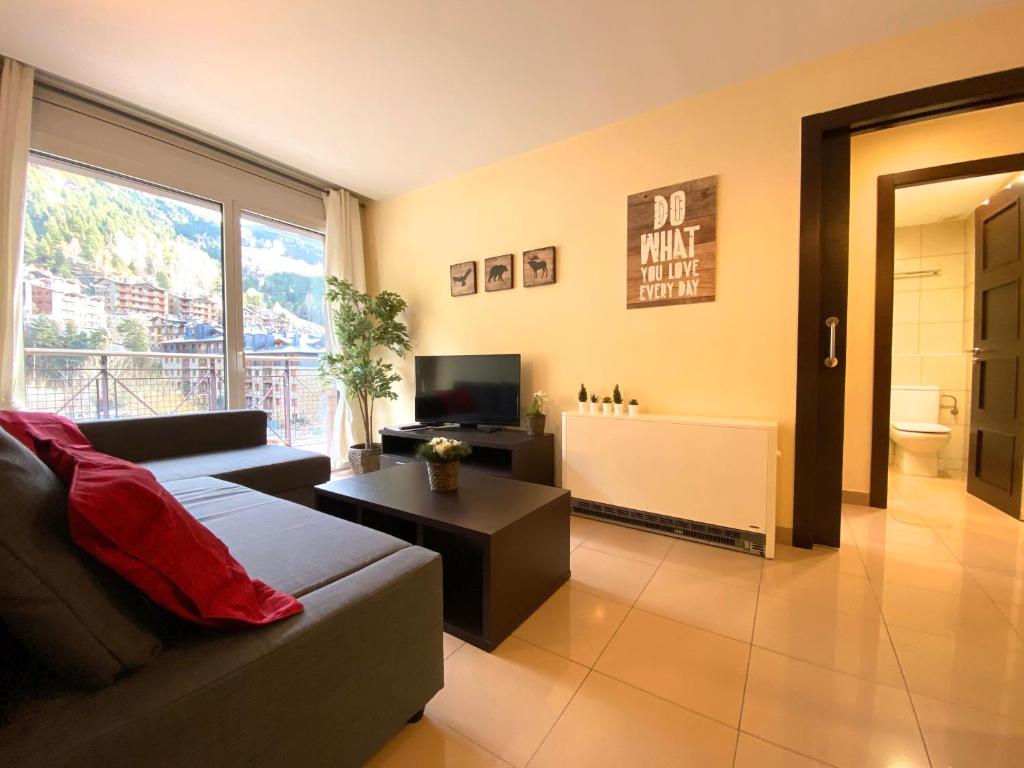 a living room with a couch and a television at Novell, Canillo centro, zona Grandvalira in Canillo