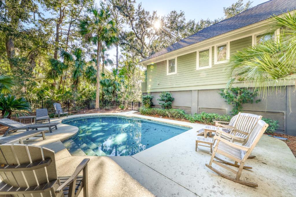 a house with a swimming pool and two lawn chairs at 207 Belted Kingfisher in Kiawah Island
