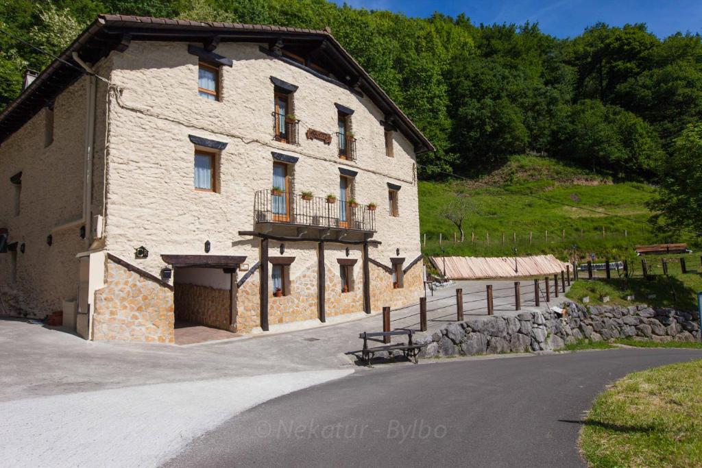 a large stone building with a balcony on the side of it at Arkaitza in Berrobi