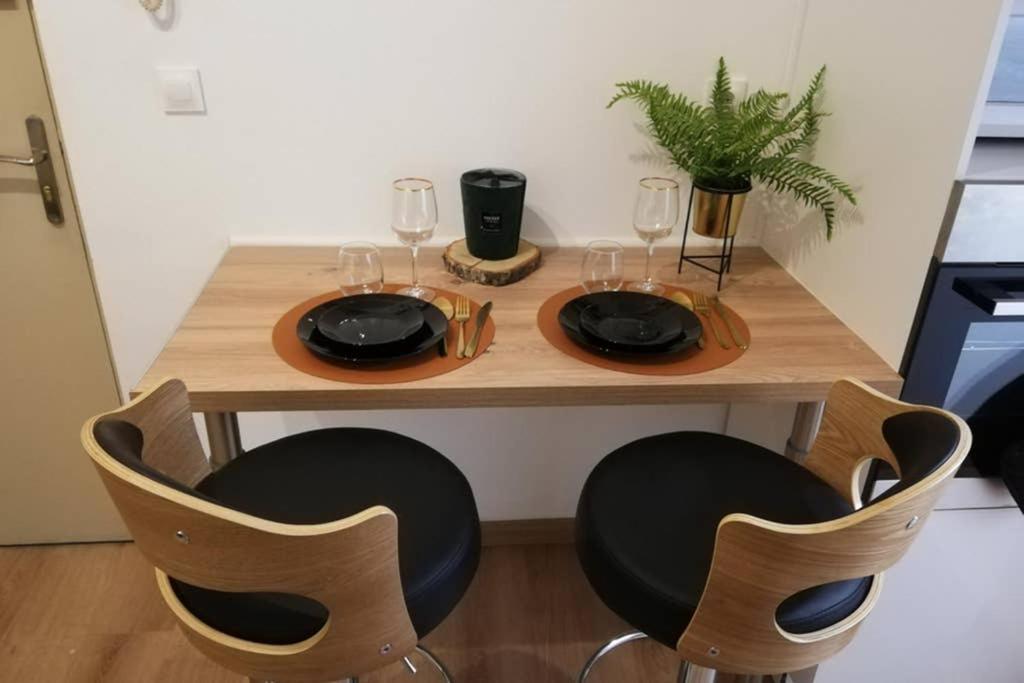 una mesa de madera con 2 sillas y copas de vino en Escapades Douaisiennes, en Douai