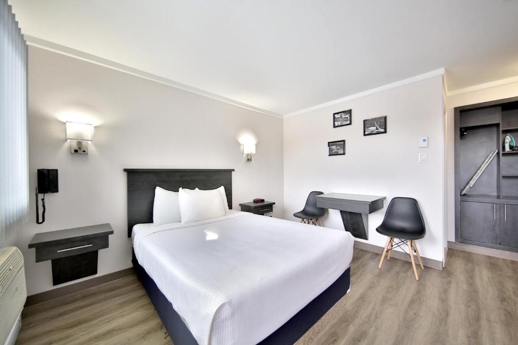 a hotel room with a bed and a desk at Motel Newstar Laval in Laval