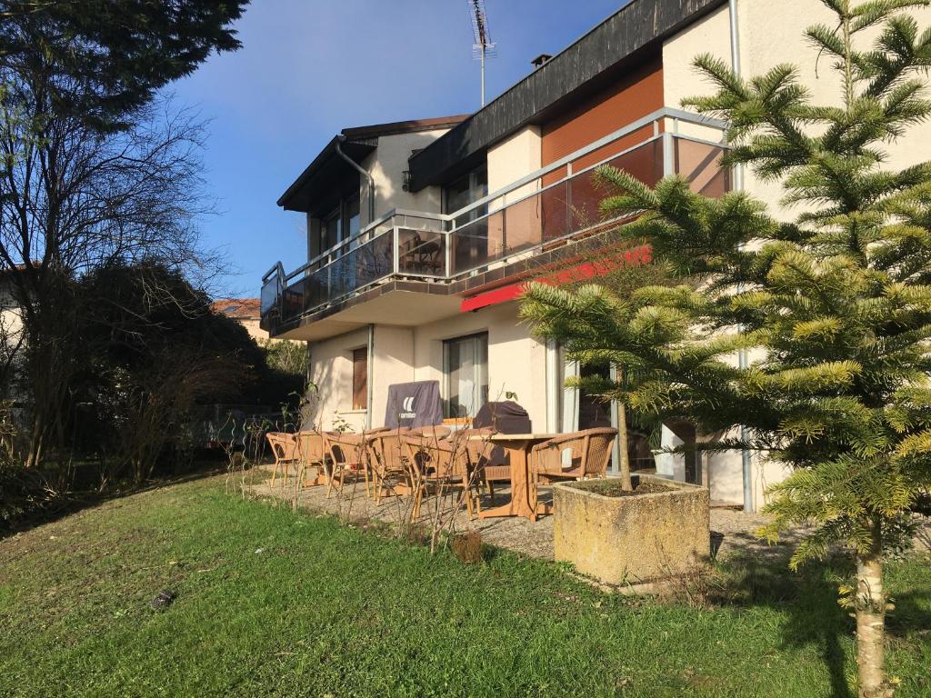 a house with tables and chairs in front of it at AU PIED DU VERCORS TOUT EST PERMIS in La Rivière