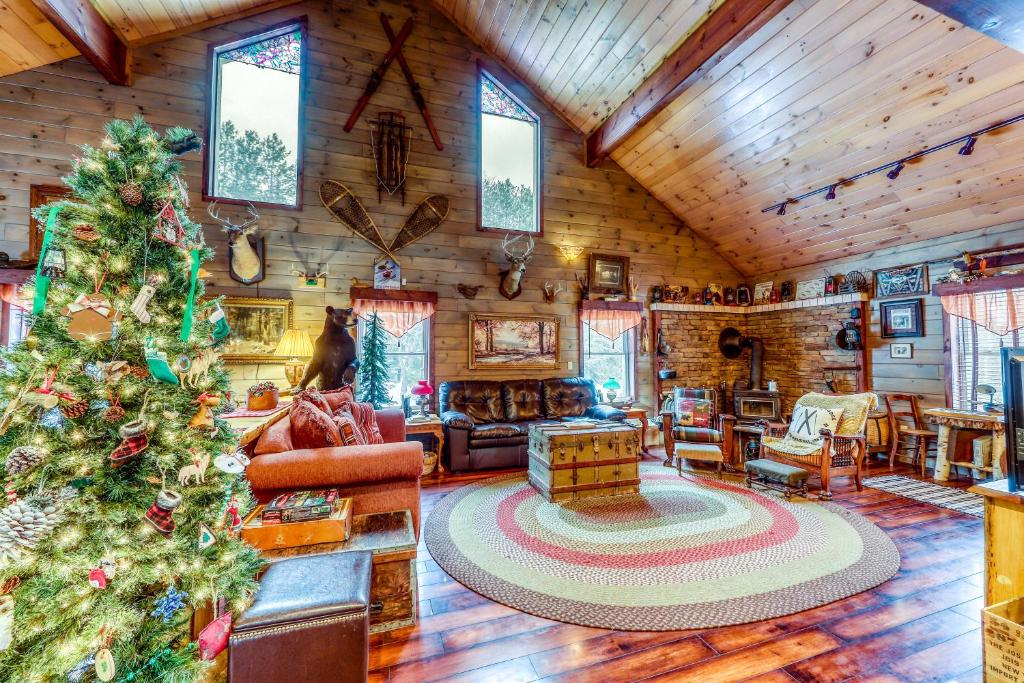a christmas tree in the living room of a log cabin at The Bear Lodge in North River