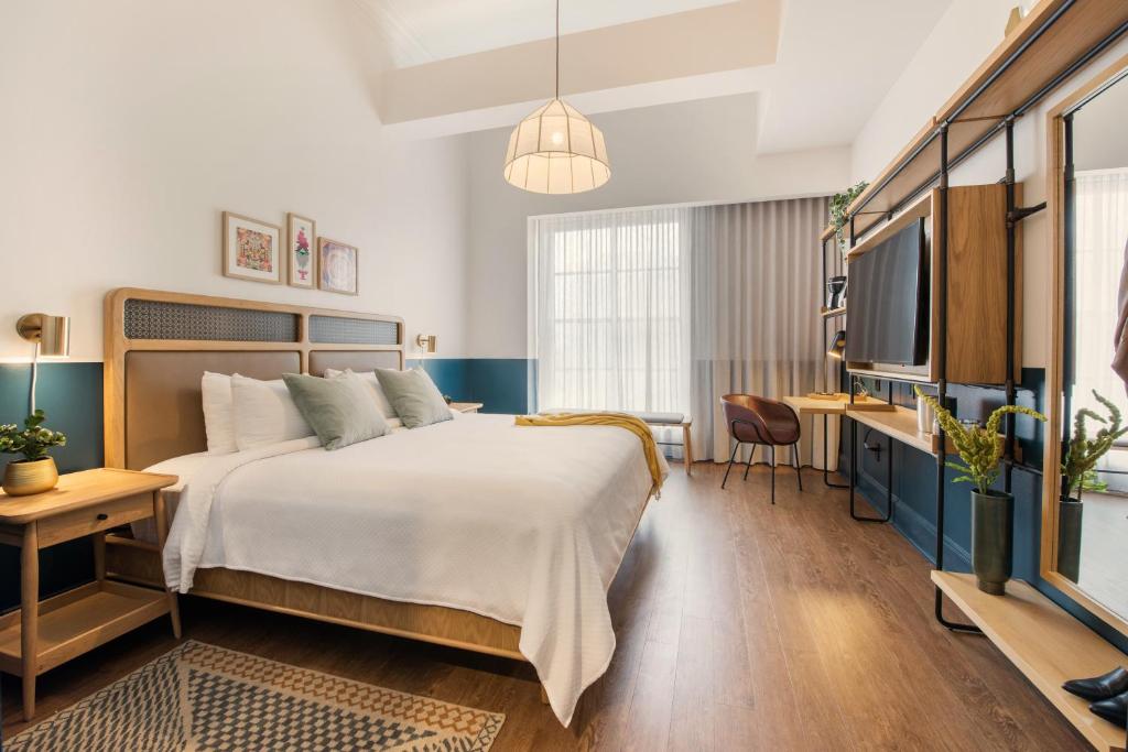 um quarto de hotel com uma cama e uma televisão em Magnolia New Orleans em Nova Orleans