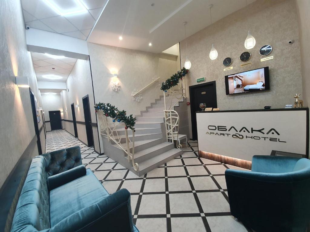 una hall con divani blu e scale in un edificio di Apart hotel Oblaka a Bijsk