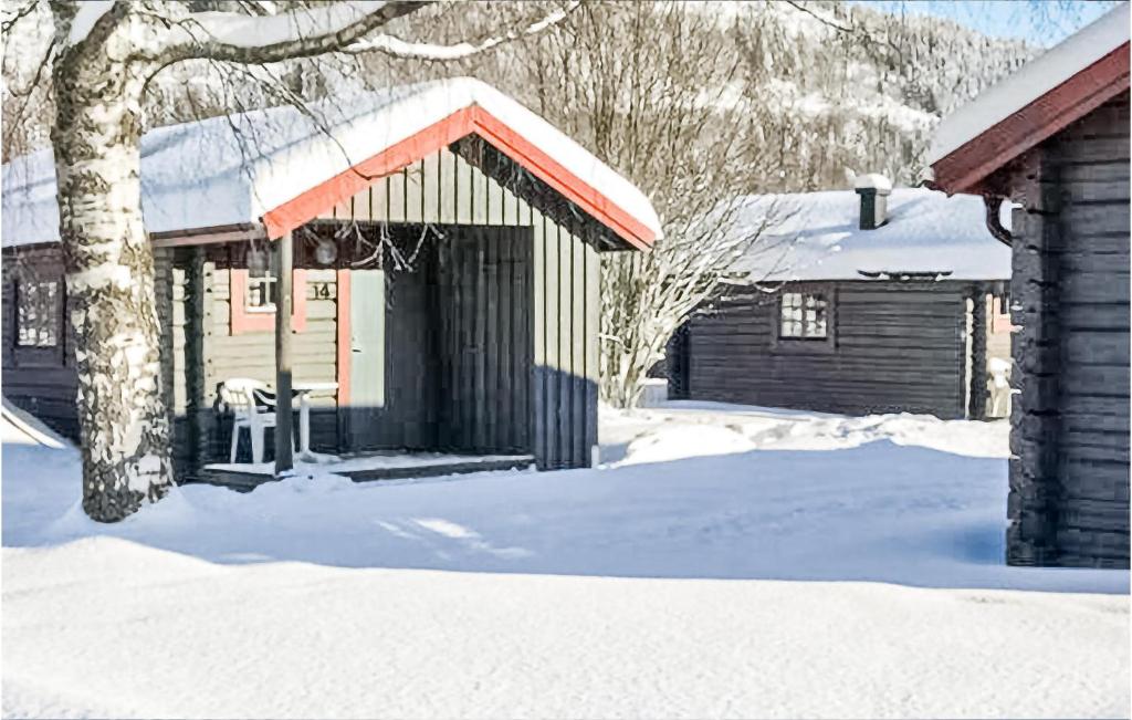 eine Hütte im Schnee mit einer Bank davor in der Unterkunft Awesome Home In Sysslebck With Kitchen in Sysslebäck