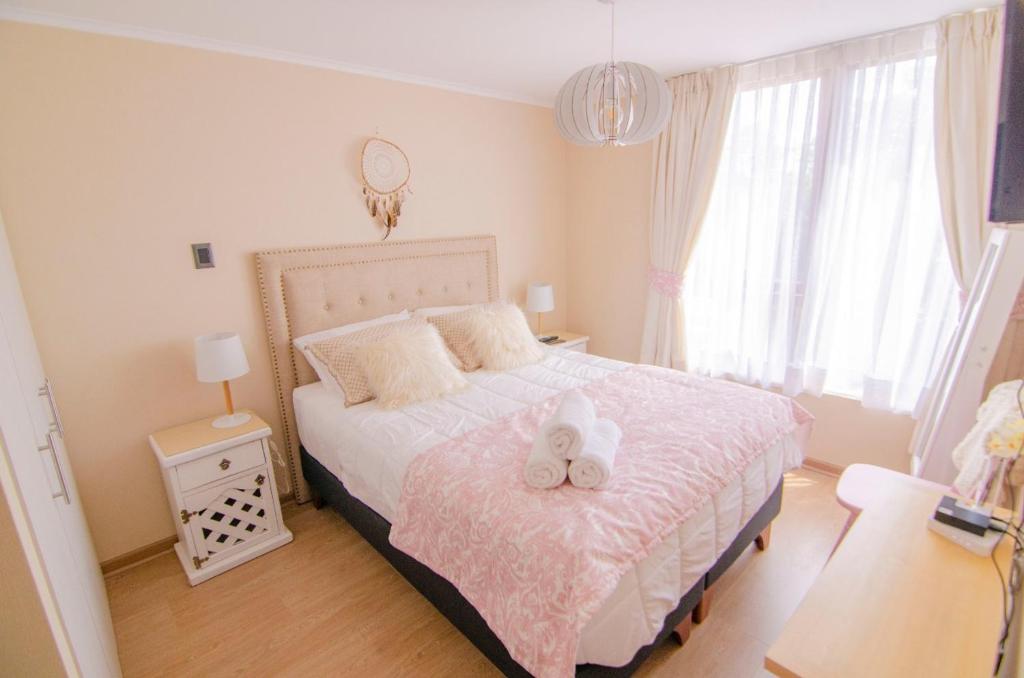 a bedroom with a bed with two stuffed animals on it at Depto primera línea de playa para 5 personas in Villarrica