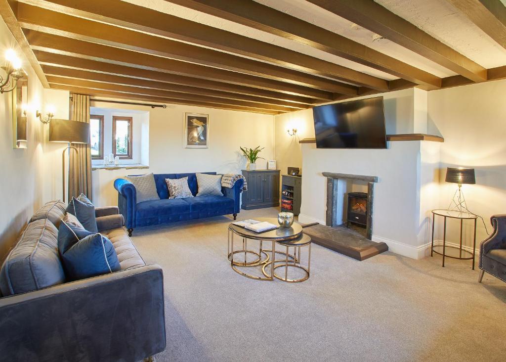 sala de estar con sofás azules y chimenea en Host & Stay - The Coach House en Whitby