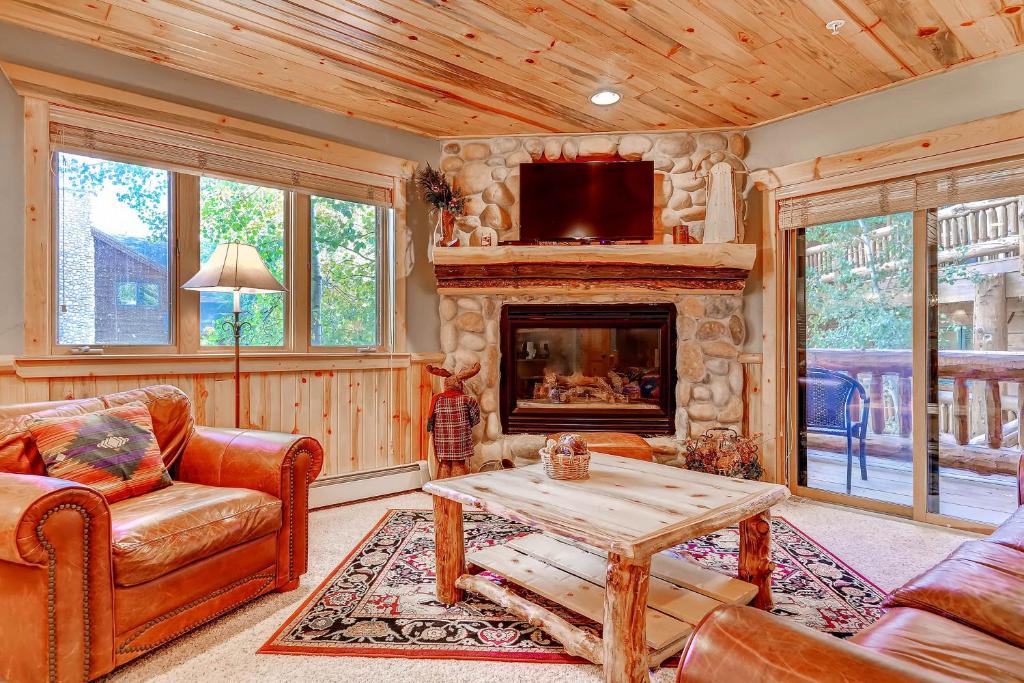 a living room with a fireplace and a tv at Timber Wolf Lodge in Park City