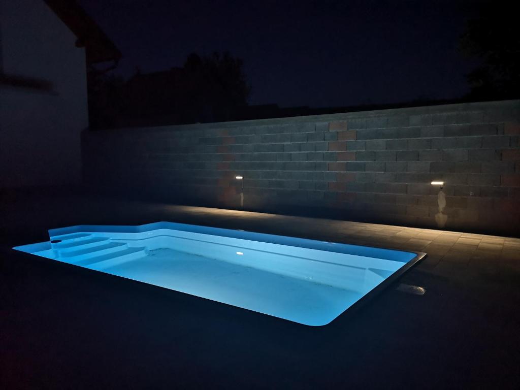 uma piscina azul no escuro com uma parede de tijolos em Yosefsfeld em Kutjevo