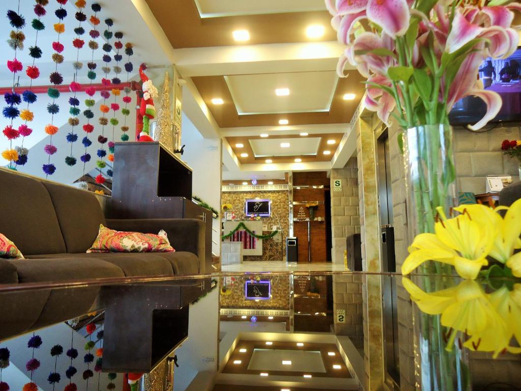 a lobby with a couch and a vase of flowers at San Francisco Cusco Hotel in Cusco