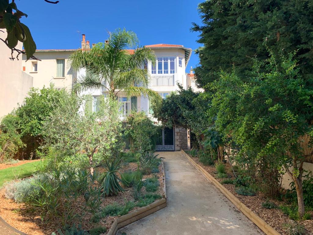 une maison avec un palmier en face d'une allée dans l'établissement VILLA PRESENCE - Chambres d'hôtes - Activités bien-être, à Toulon