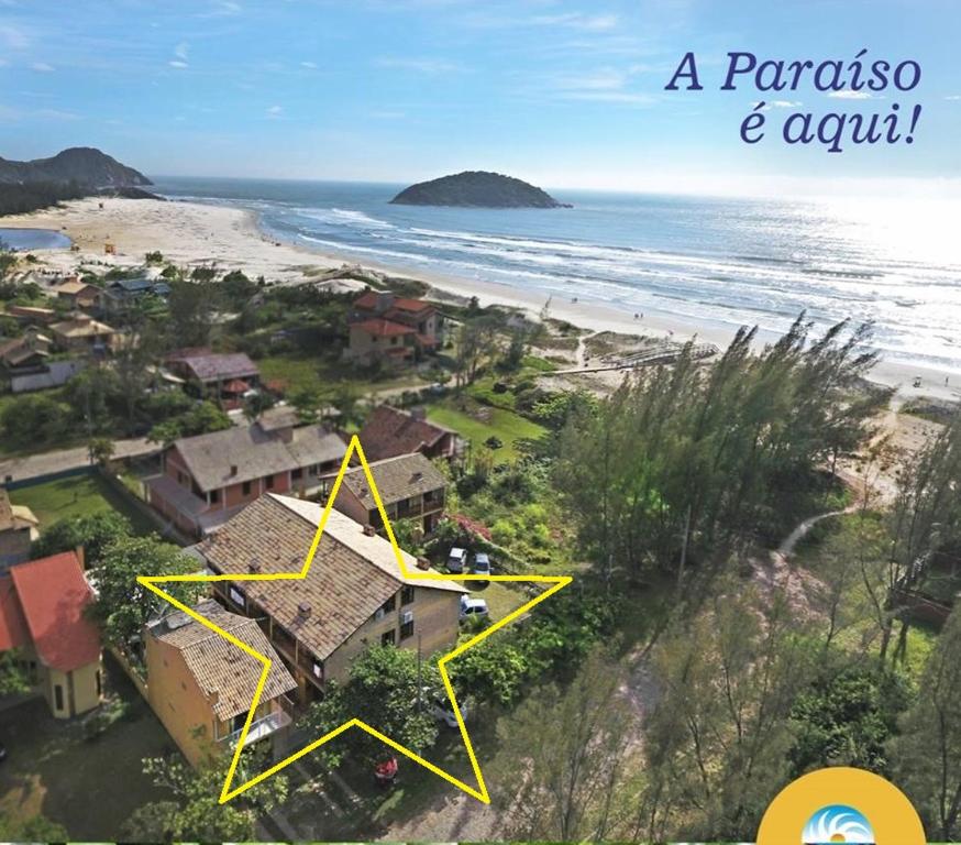 a house on a beach with a yellow star at Pousada do Paraiso in Barra de Ibiraquera