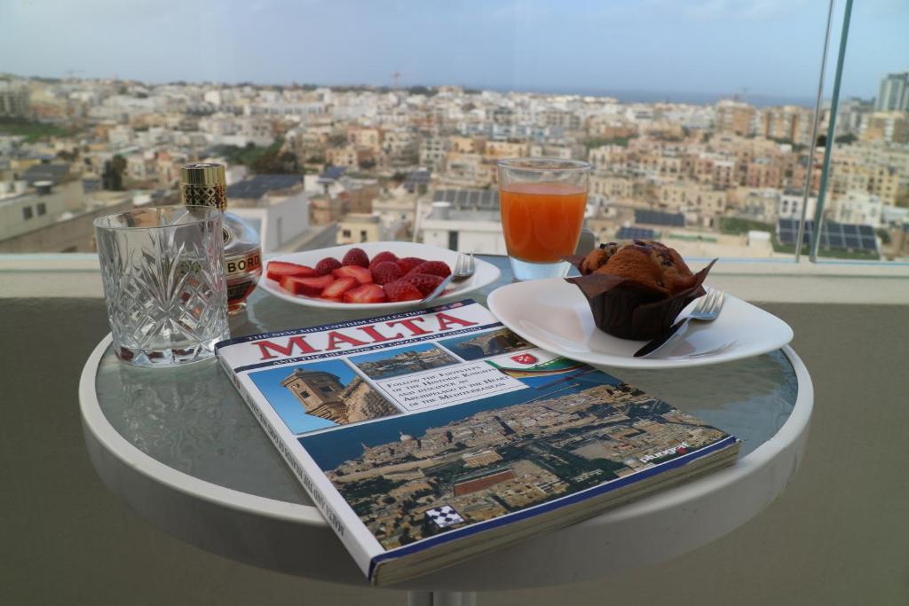 a table with food and a magazine and a drink at Escape to St Julians in St. Julianʼs