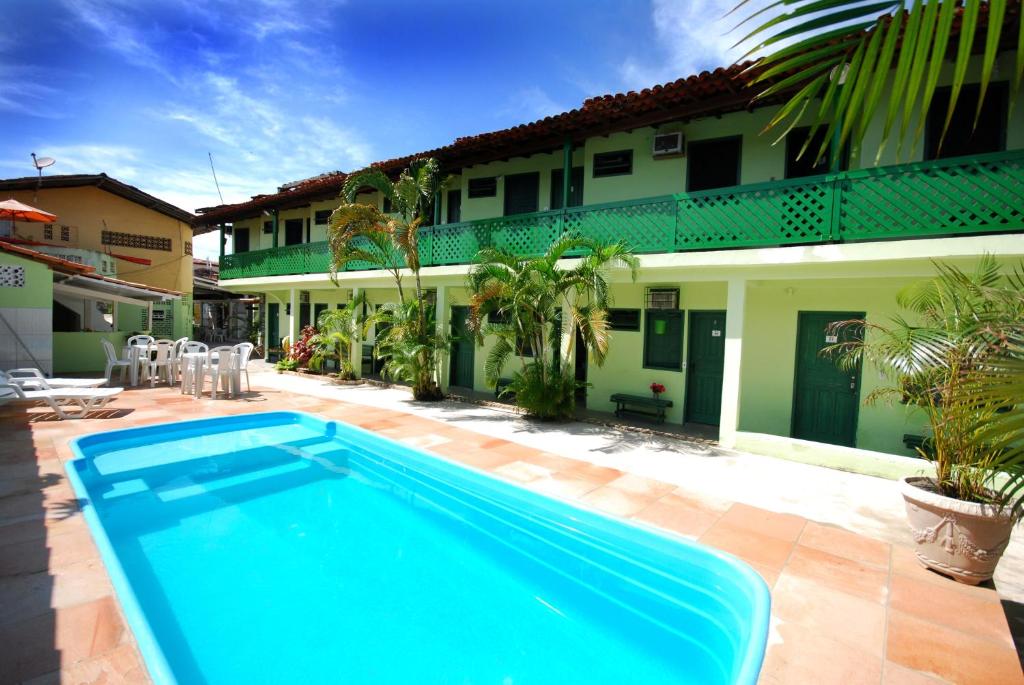 a swimming pool in front of a house at Pousada Tapuia in Porto Seguro