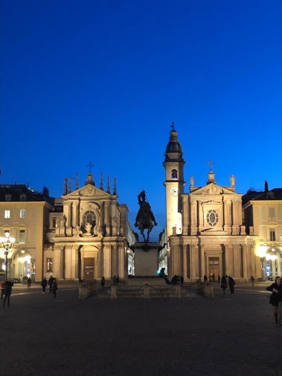 un bâtiment avec une tour d'horloge et une statue dans l'établissement Artua'&Solferino, à Turin