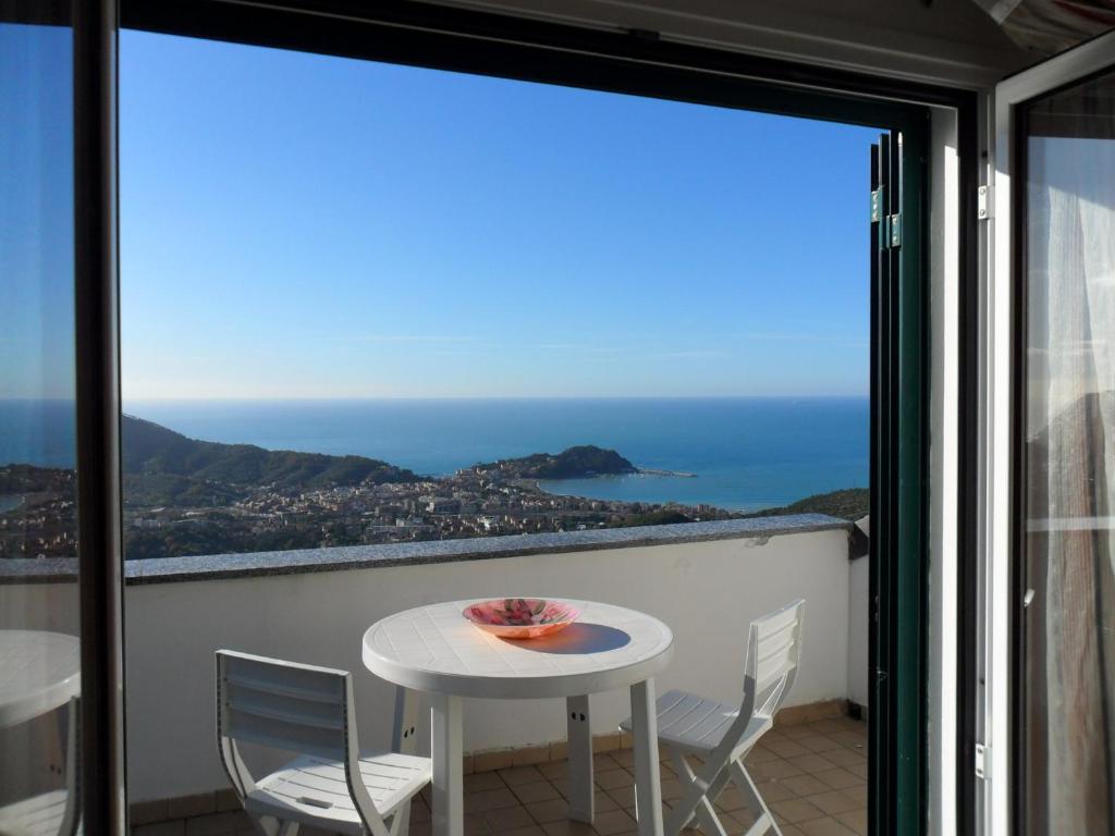 un tavolo e sedie su un balcone con vista sull'oceano di MANSARDA PARADISO GOLFO DI PORTOFINO a Sestri Levante