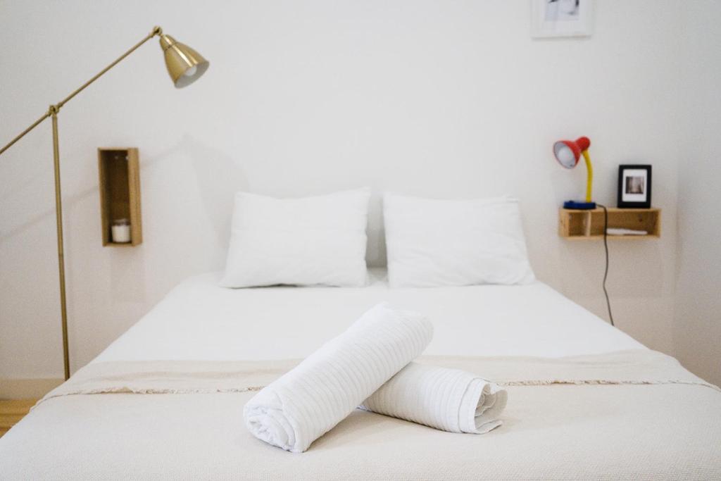 sypialnia z białym łóżkiem i ręcznikami w obiekcie Cosy and Modern Flat in Porto w Porto