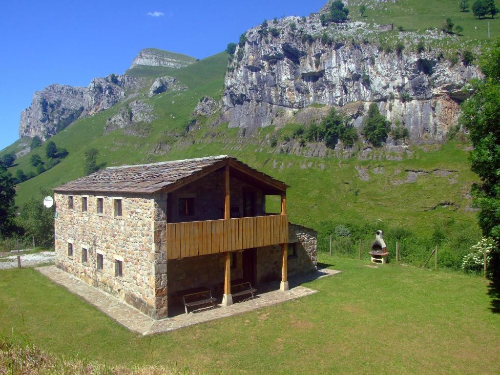 un piccolo edificio in un campo con una montagna sullo sfondo di Las Hayucas a San Roque de Ríomiera