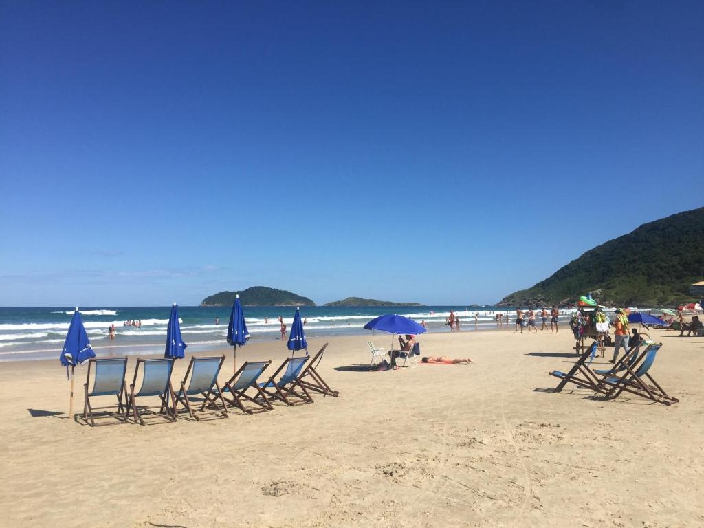 um grupo de cadeiras e guarda-sóis numa praia em COSTÃO DAS GAIVOTAS: HOSPEDE -SE NO PARAÍSO em Florianópolis