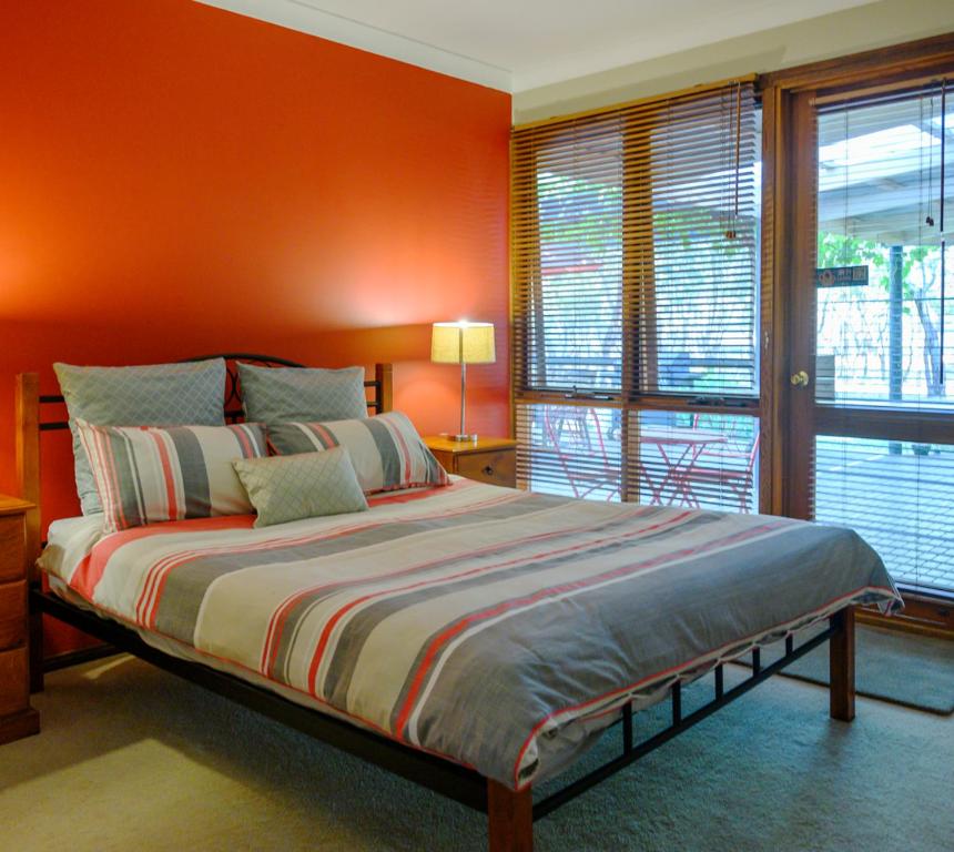 1 dormitorio con paredes de color naranja y 1 cama grande en Friends at McLaren Vale en McLaren Vale