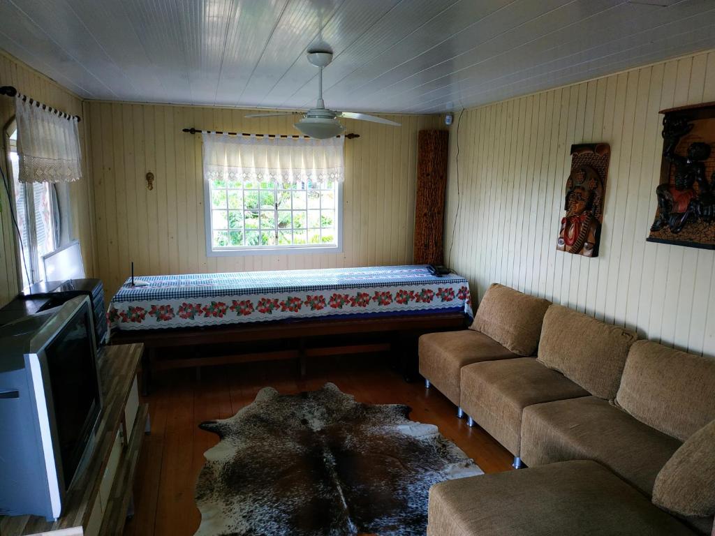 a living room with a couch and a window at A Casa do Rio in Lages