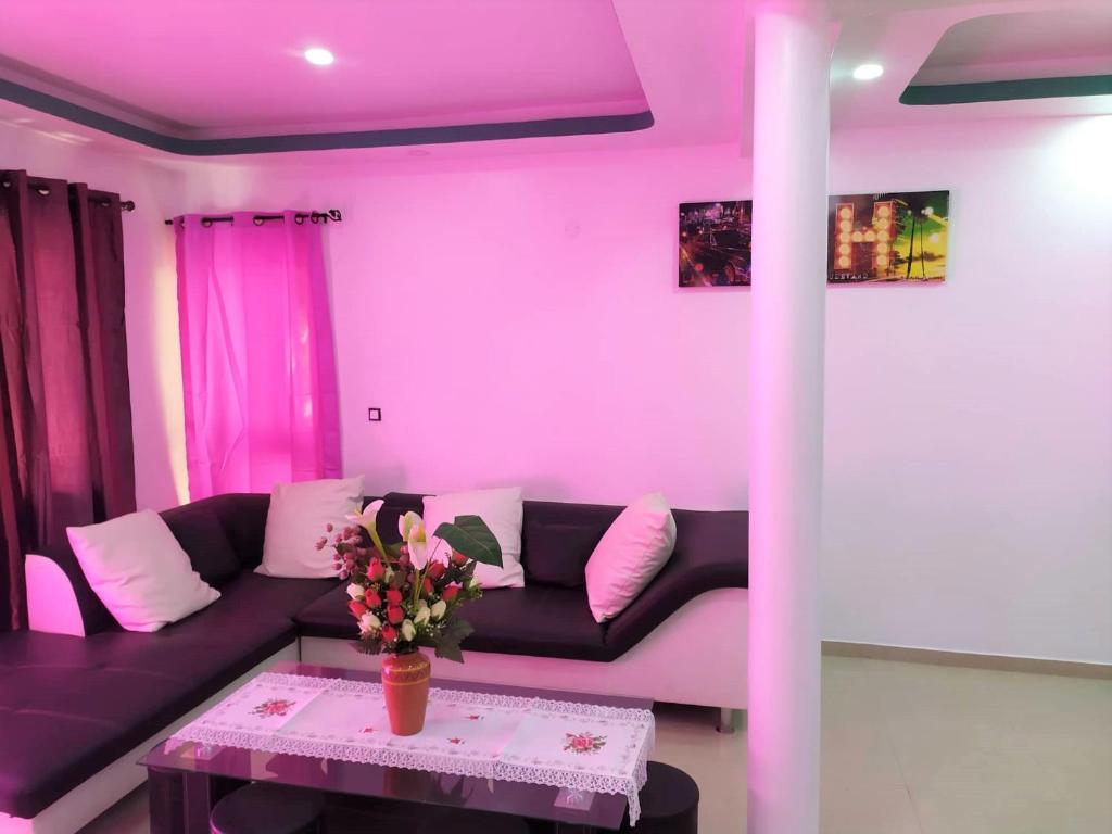uma sala de estar com um sofá e uma mesa com flores em Casa Cabral : Big Apartment next to the beach em Tarrafal
