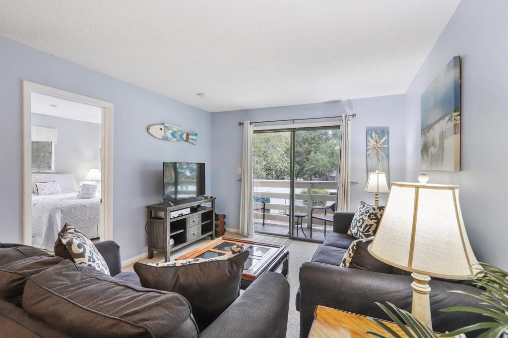 a living room with couches and a tv at 5 stars Peaceful Condo - 7 min walk to the beach in Hilton Head Island