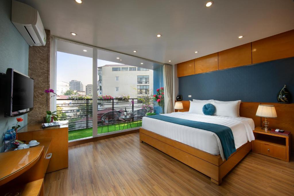 a bedroom with a large bed and a large window at Hanoi Lotus Boutique Hotel in Hanoi