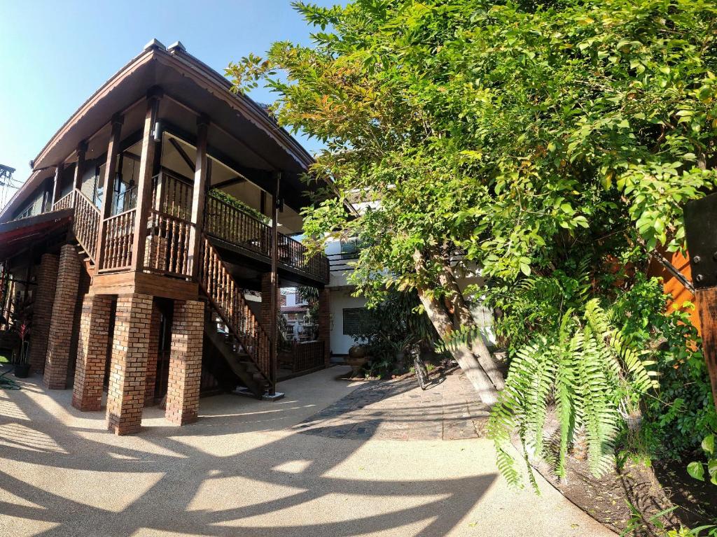 a building with a balcony on the side of it at Sarah Guest House in Chiang Mai