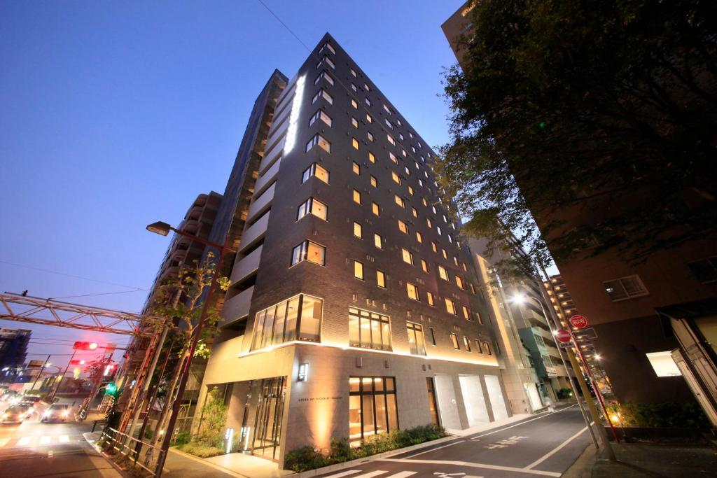 a tall building on a city street at night at S-peria Inn Nihombashi Hakozaki in Tokyo