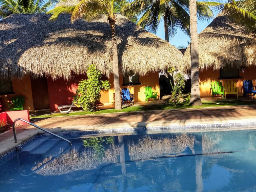 a swimming pool in front of a resort with palm trees at Dulce y Salado in La Curbina
