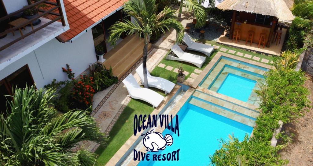 an overhead view of a swimming pool with chairs and a house at Ocean Villa Dive Resort - Tulamben in Tulamben