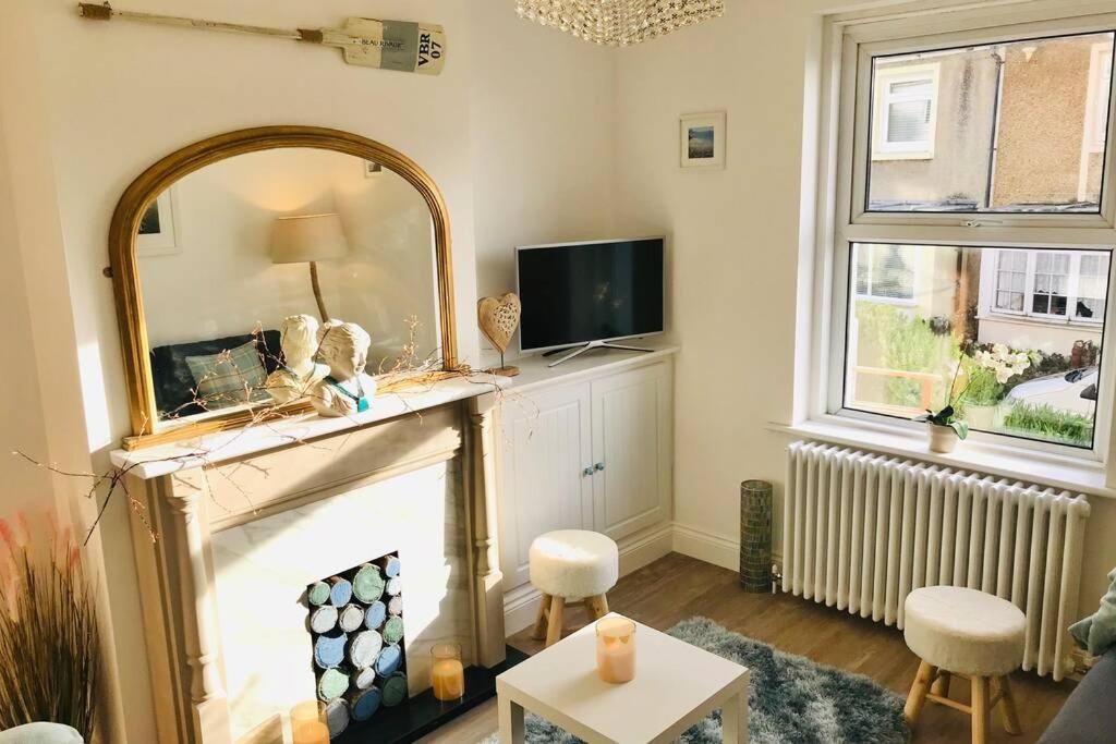 a living room with a mirror and a fireplace at Seascape Cottage, Ventnor in Ventnor