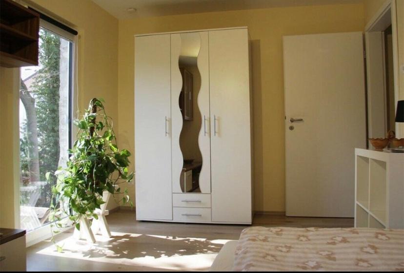 ein Schlafzimmer mit einem großen weißen Schrank und einer Pflanze in der Unterkunft Ferienwohnung mit Balkon in Schmölln in Schmölln