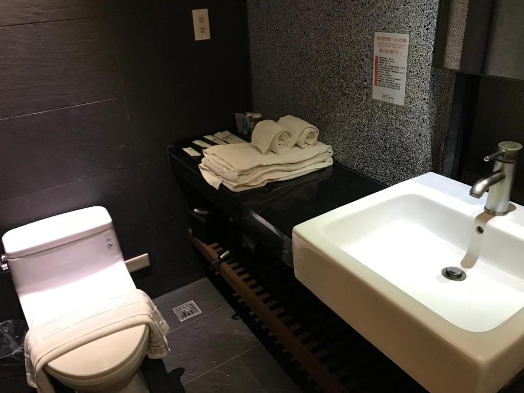 a bathroom with a toilet and a sink at Shan-Yue Hotspring Hotel in Taipei