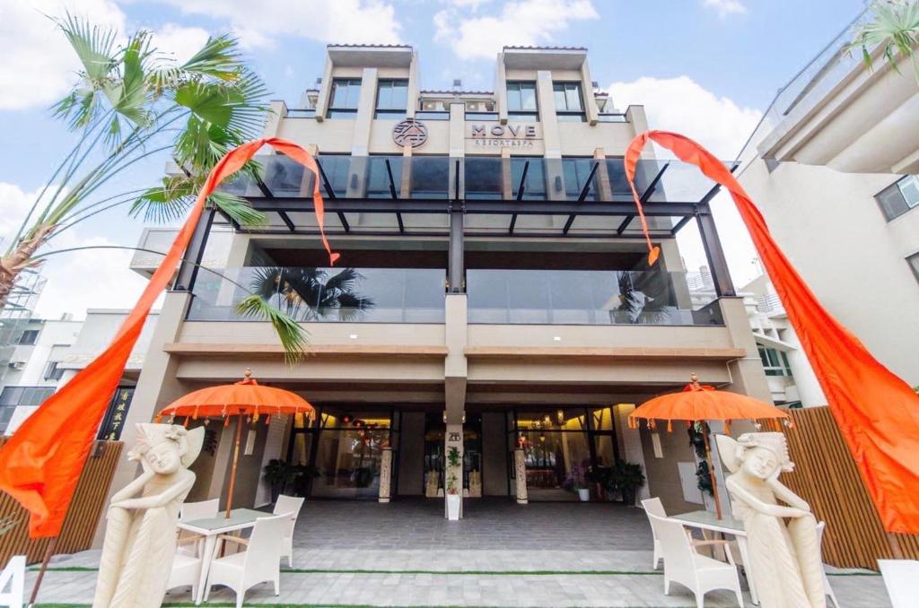 un edificio con banderas naranjas delante de él en Move Resort & Spa en Anping