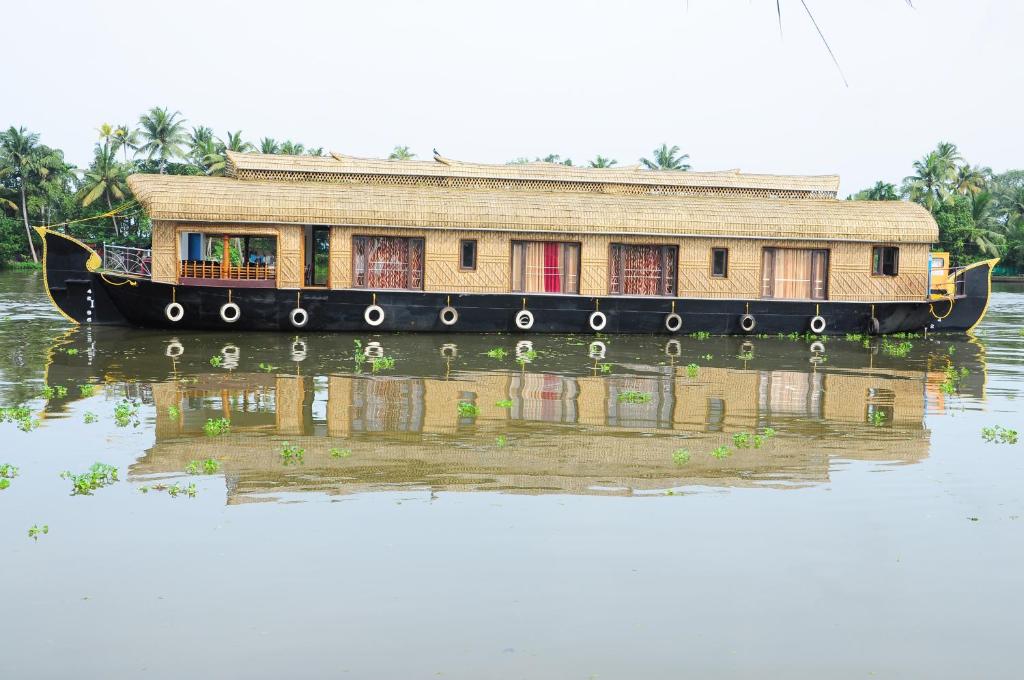 a boat in the water with a house on it at Shivaganga Houseboat- VACCINATED STAFF in Kumarakom